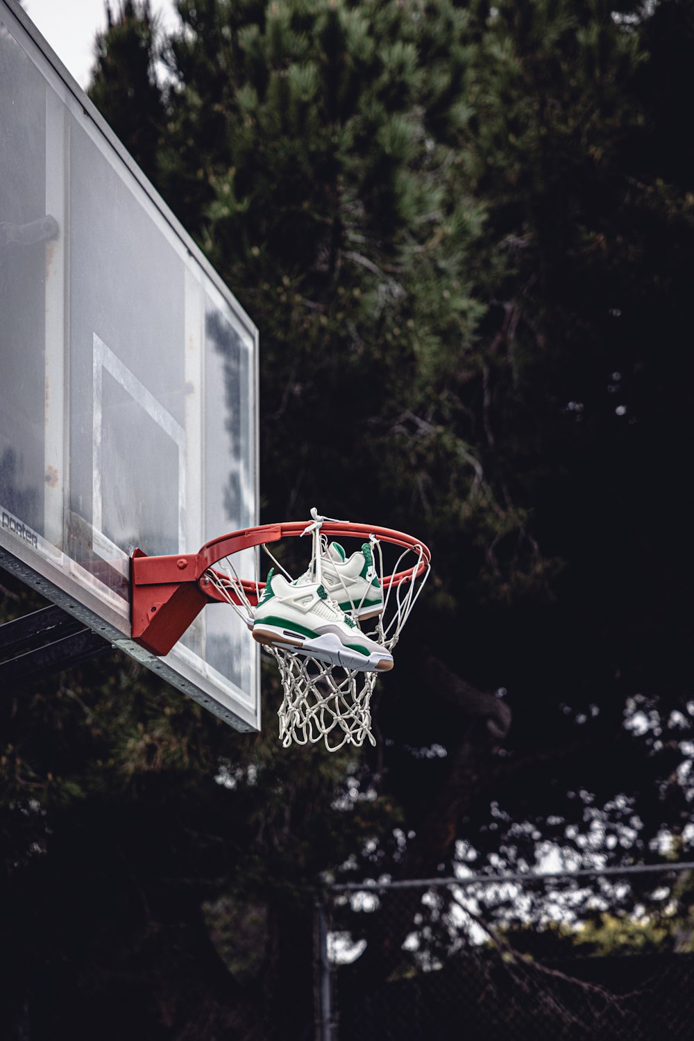 a basketball going through the hoop with trees in the background