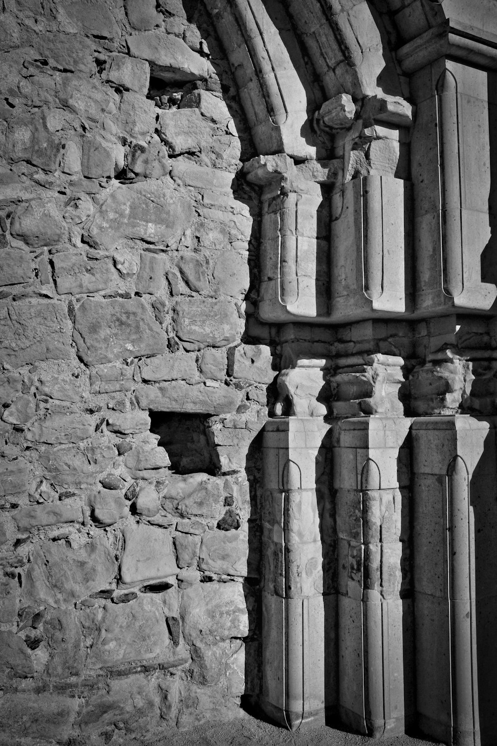 Une photo en noir et blanc d’un bâtiment en pierre