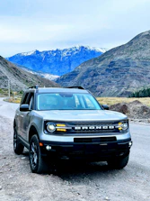 A sturdy SUV positioned near a scenic outdoor location with mountains.