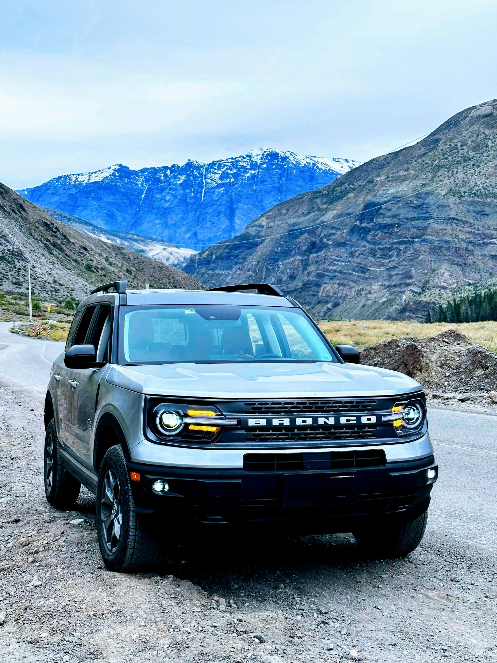 A rugged SUV parked outdoors with a scenic mountain backdrop, highlighting its sturdy build and spacious interior.