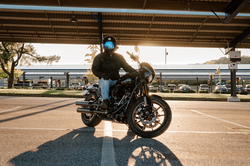 a man sitting on a motorcycle in a parking lot