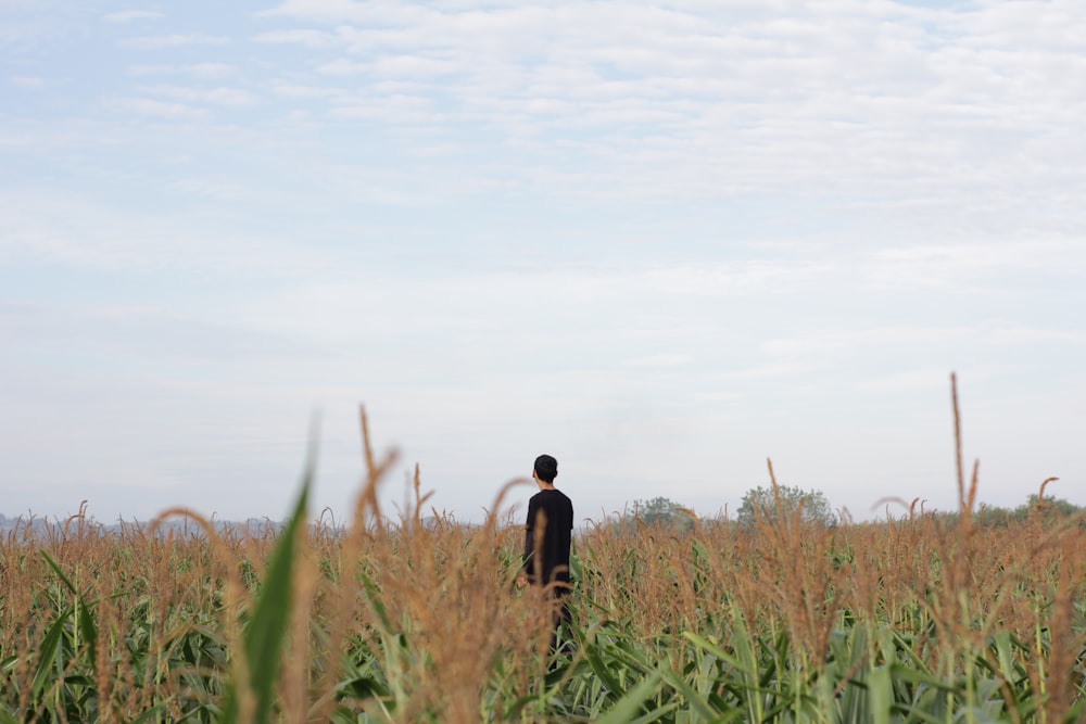 a man standing in a field of tall grass