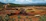 A panoramic view of a modern African mining site with heavy machinery at work under a golden sunset.