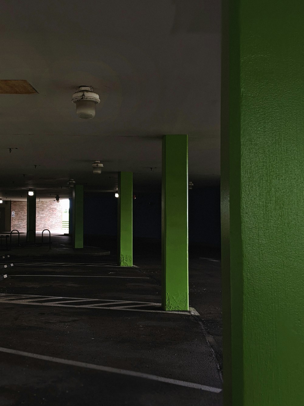 an empty parking garage with green columns