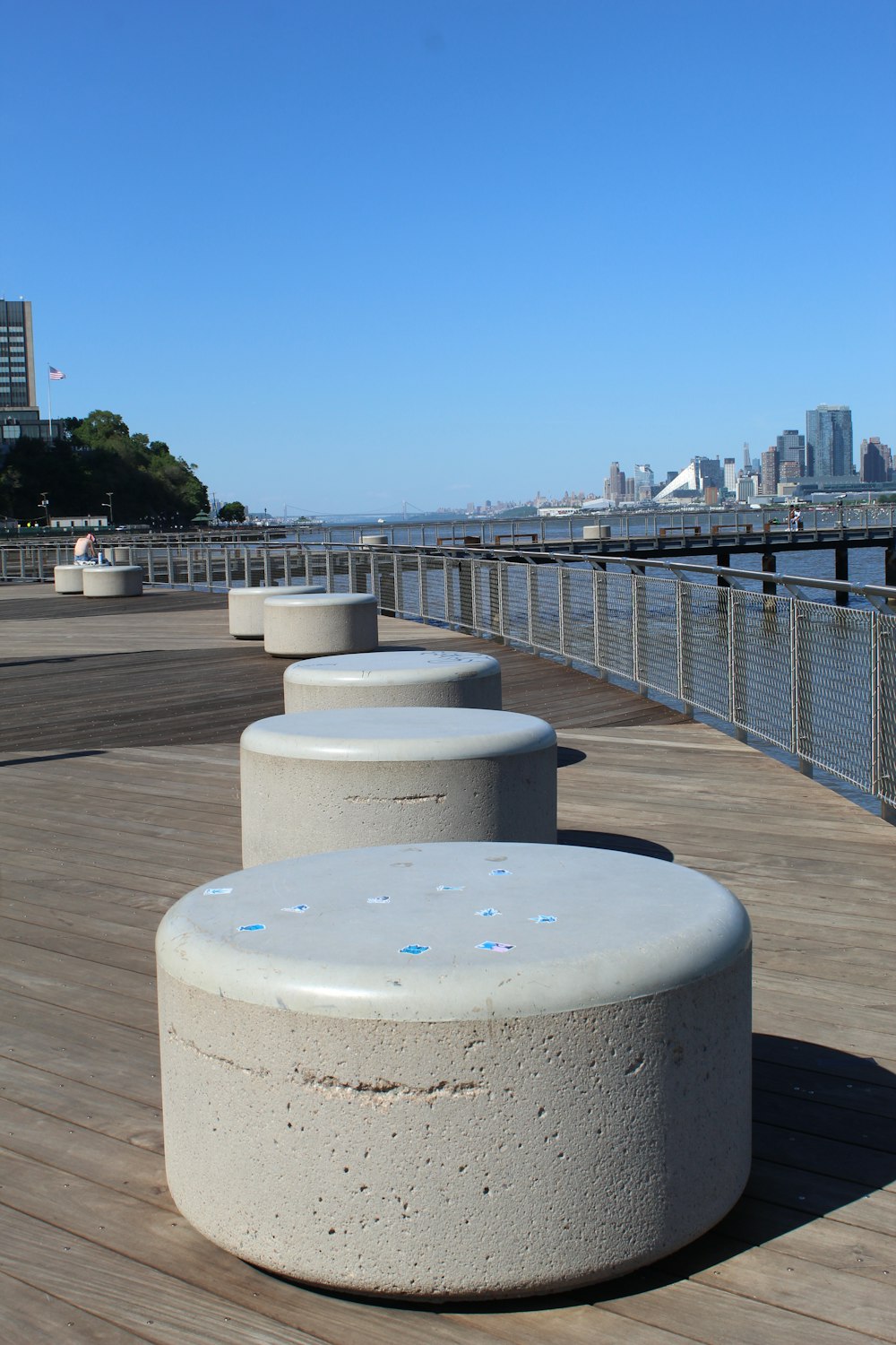 a row of concrete benches sitting on top of a wooden pier