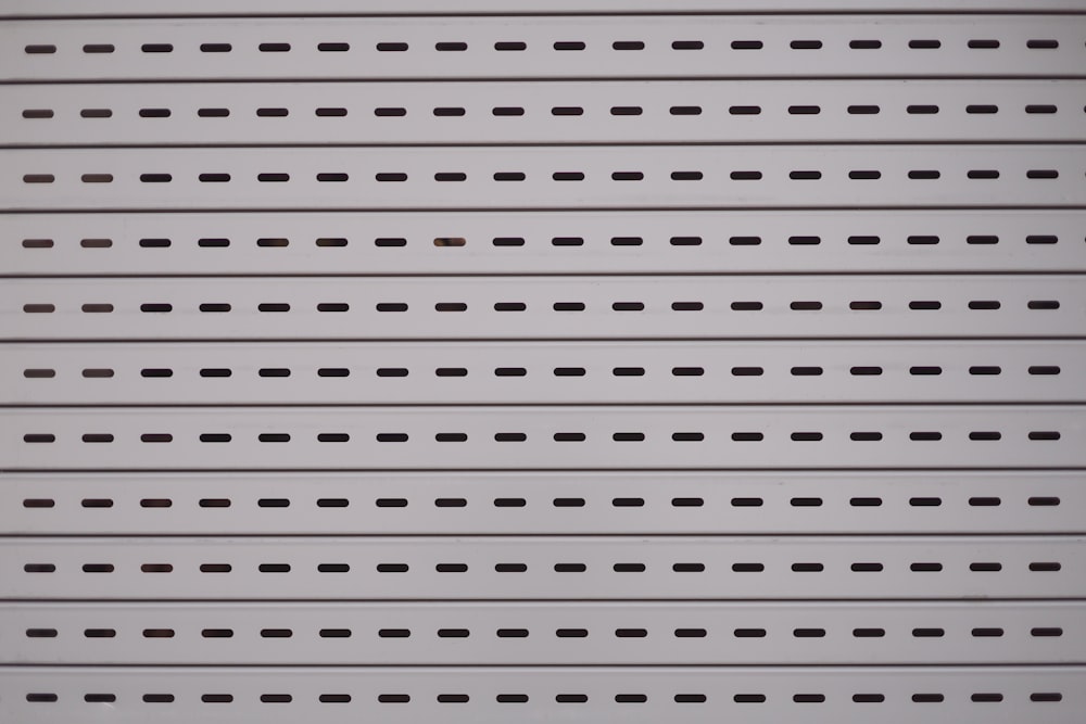 a close up of a white wall with black dots