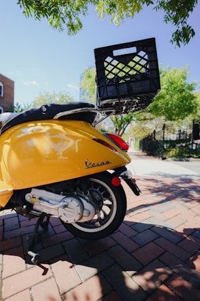 Vintage Piaggio Ape triporteur decorated with Sicilian cart motifs, parked on a sunlit street in Aix-en-Provence.