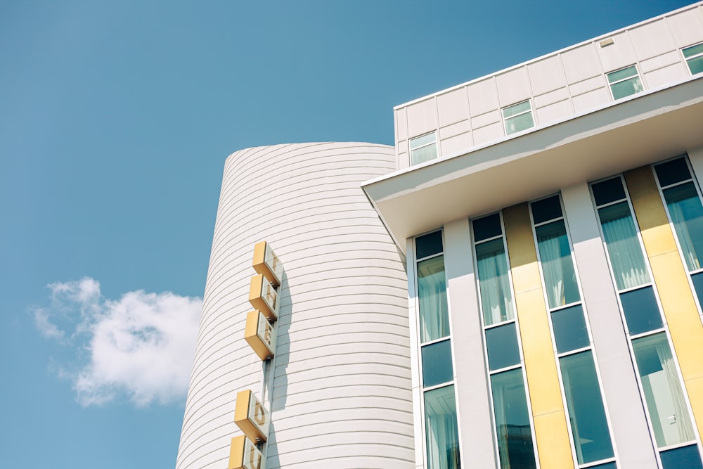 a tall white building next to a tall yellow and white building