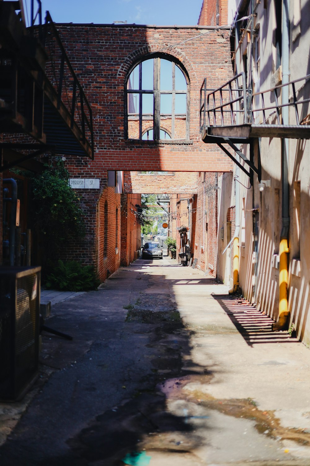 a narrow alley way with a brick building in the background