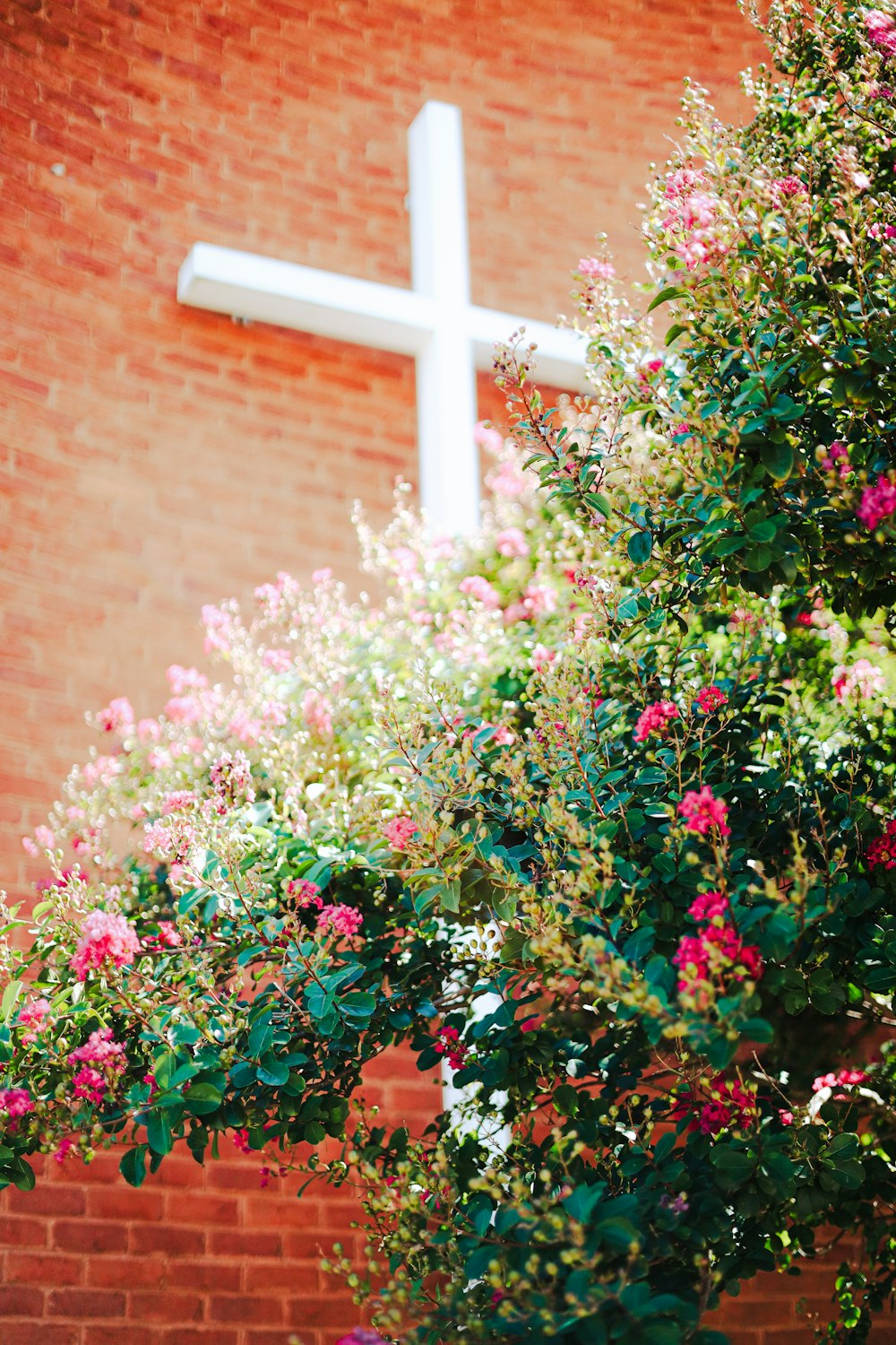 a cross on the side of a brick building