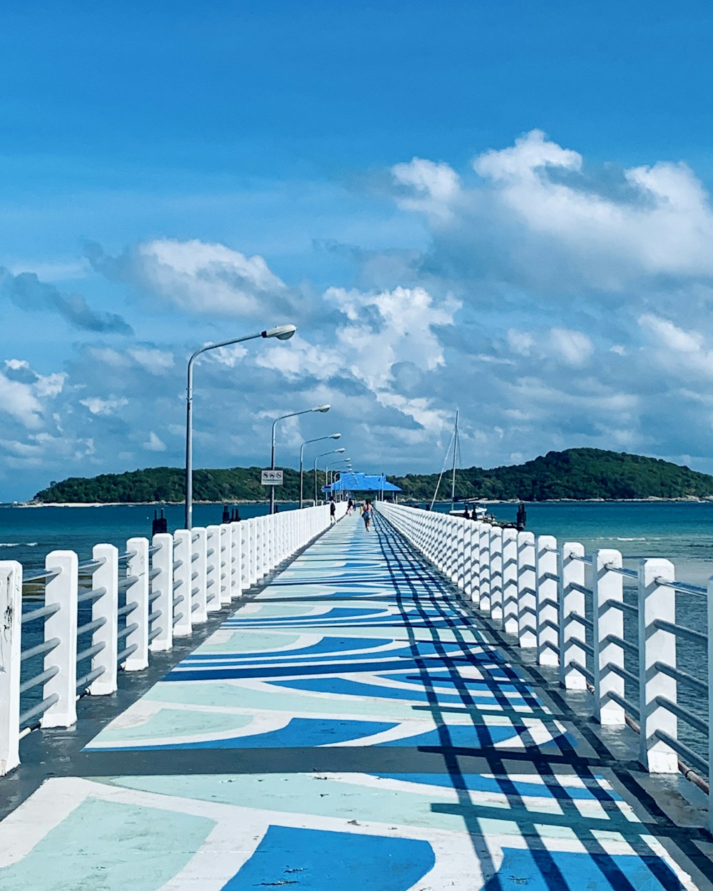 a long pier with a blue and white painted walkway
