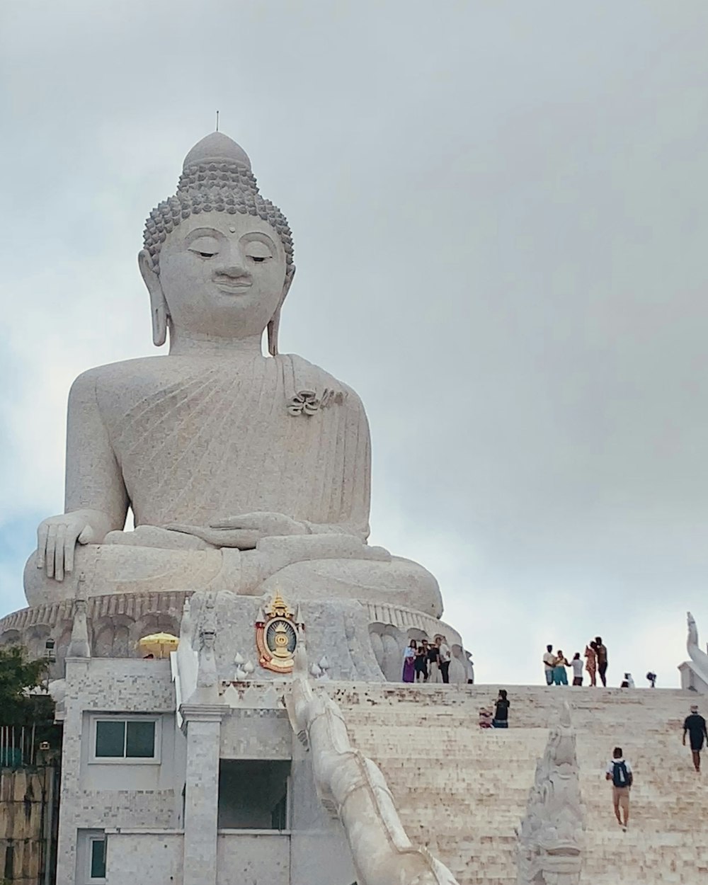 a large buddha statue sitting on top of a hill