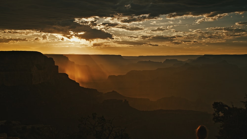 the sun shines through the clouds over a canyon