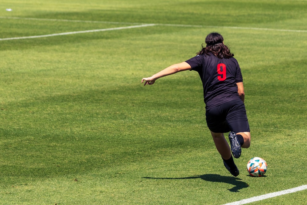 a person kicking a soccer ball on a field