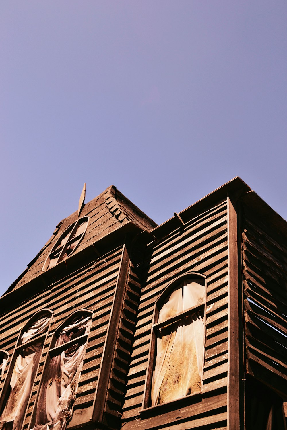 a tall wooden building with a clock on it's side