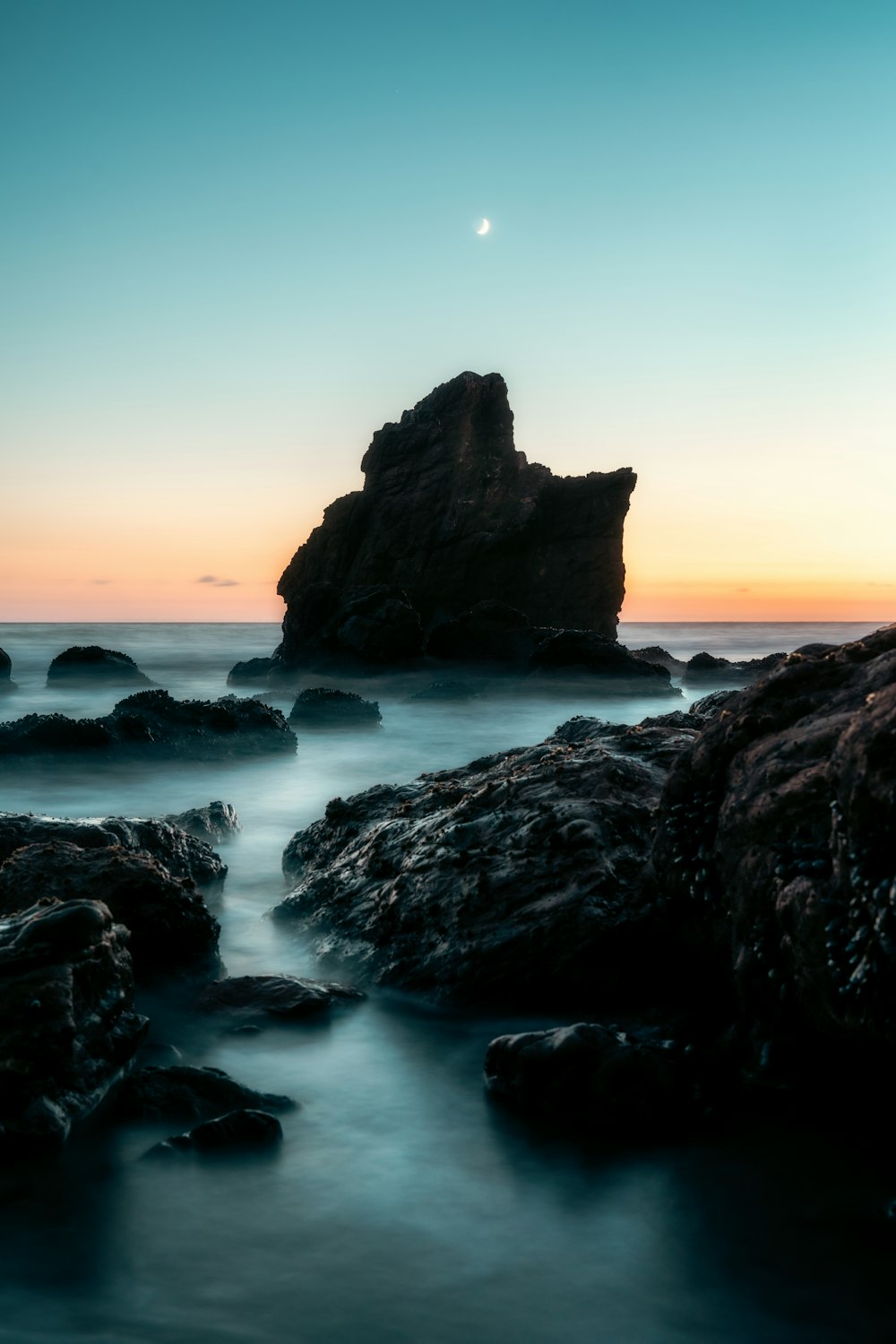 a long exposure photo of the sun setting over the ocean