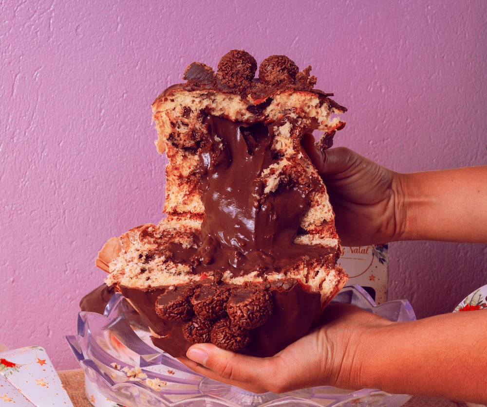 a person holding a piece of cake in their hand