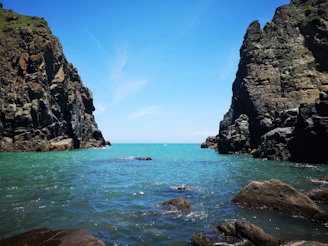 A breathtaking view of the rugged Sardinian coastline from Masua to Piscinas, with turquoise waters and golden cliffs under a clear sky.
