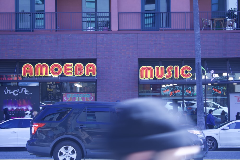 a blurry photo of a car parked in front of a music store
