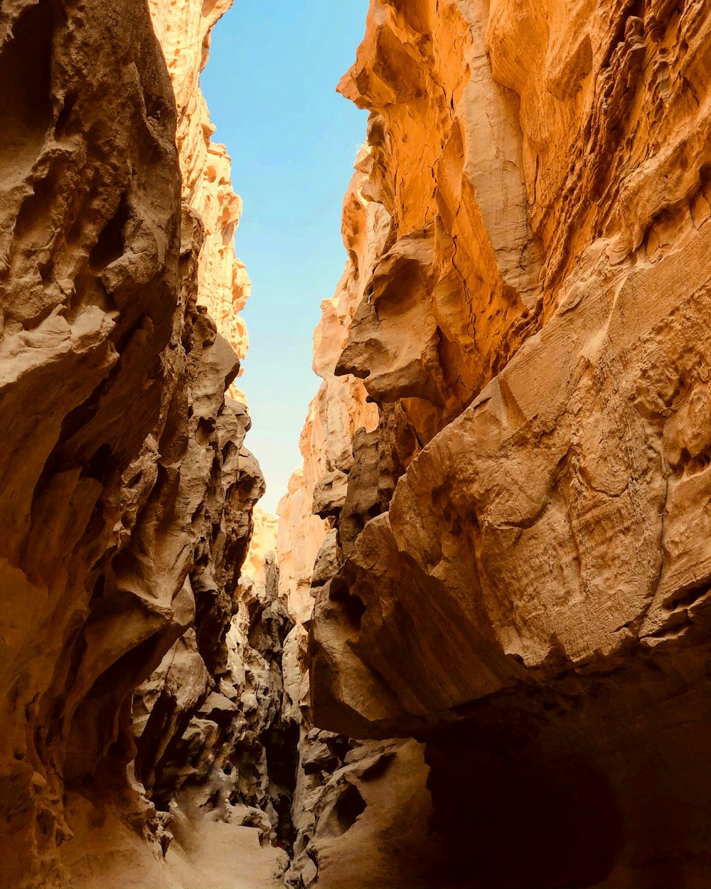 a narrow narrow canyon with a person walking through it