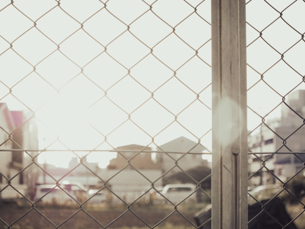 a view of a city through a chain link fence