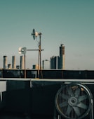 Engineers setting up IoT devices on a rooftop with city skyline in the background.