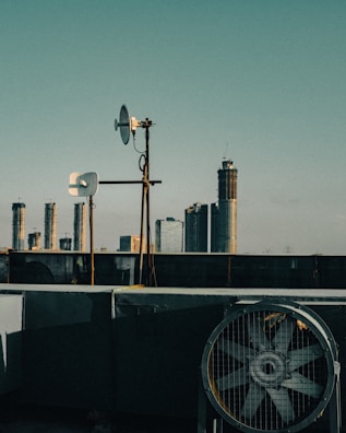 Engineers setting up IoT devices on a rooftop with city skyline in the background.