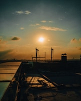 Sunset casting warm light on a completed solar panel installation at an industrial site.