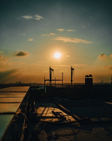 Sunset casting a warm orange glow over a well-maintained roof, symbolizing care and longevity.