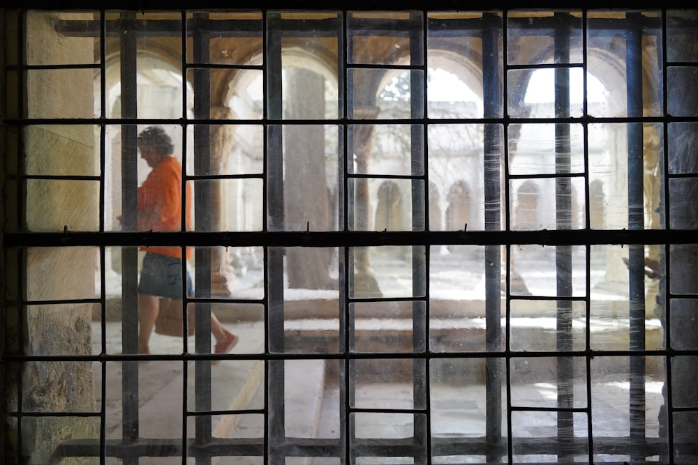 a person is walking through a window with bars