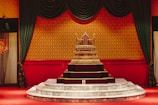 A beautifully decorated wedding altar with black and gold drapes under soft lighting.