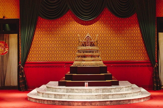 A beautifully decorated wedding altar with black and gold drapes under soft lighting.