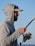 a man in a hoodie holding a fishing rod