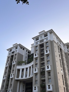 Modern residential buildings with landscaped gardens under clear sky.