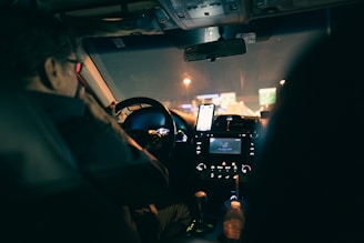 a man driving a car at night in the dark