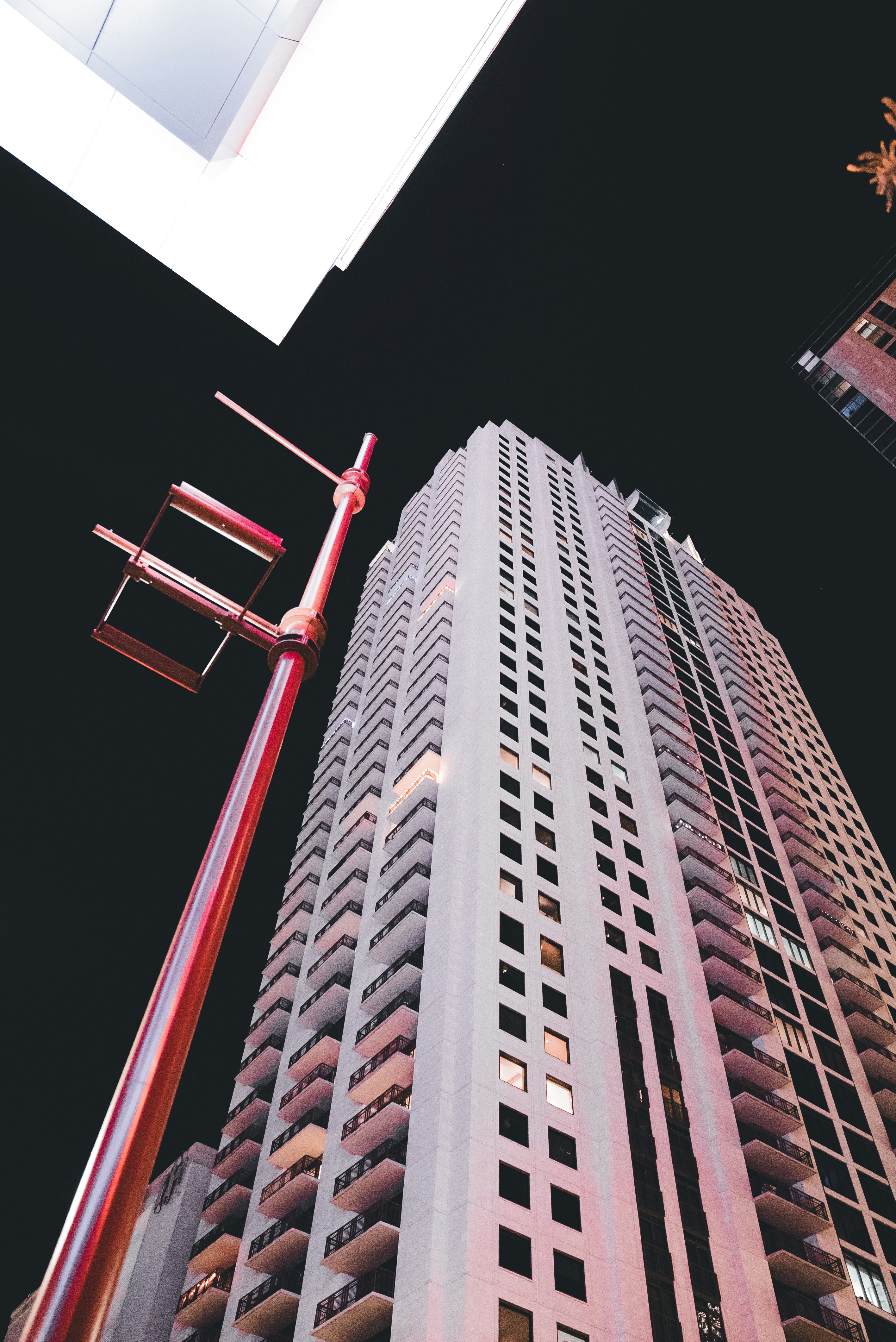 A tall building with a red light on top of it photo Free City Image