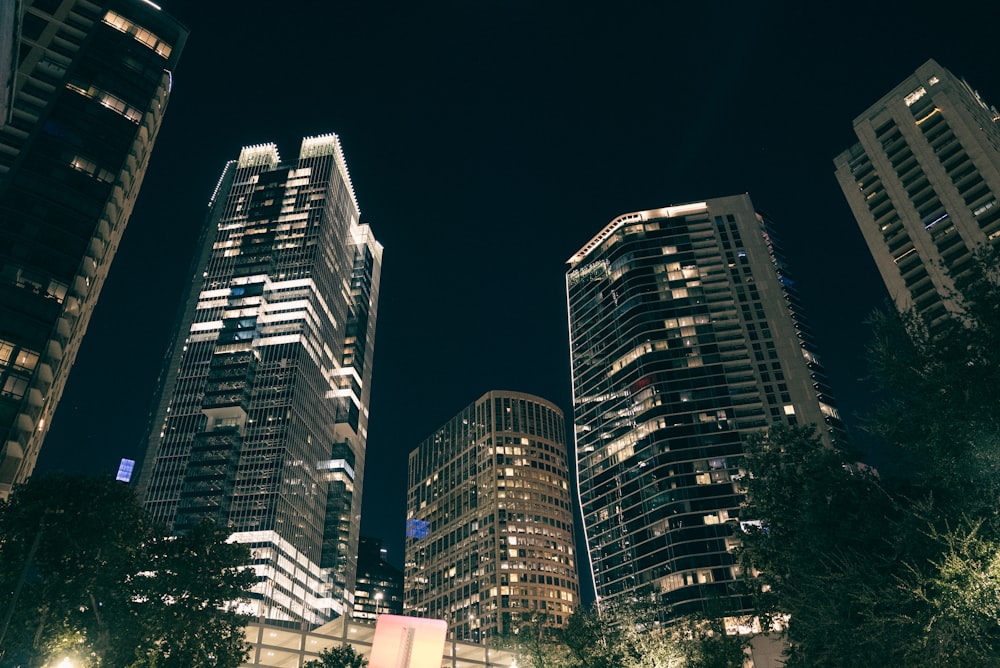 a group of tall buildings lit up at night