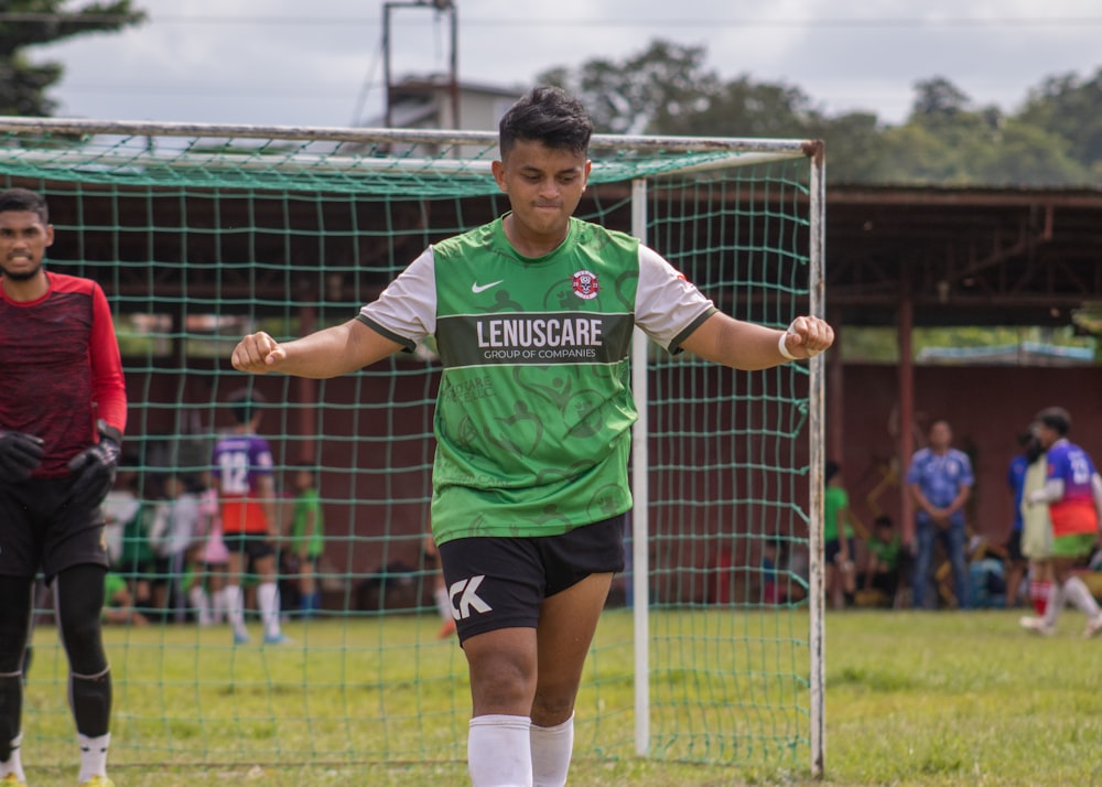 a young man kicking a soccer ball around a field