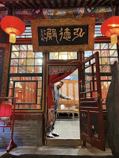 Close-up of a beautifully handcrafted paddy toran in warm gold and beige hues hanging on a traditional wooden door.