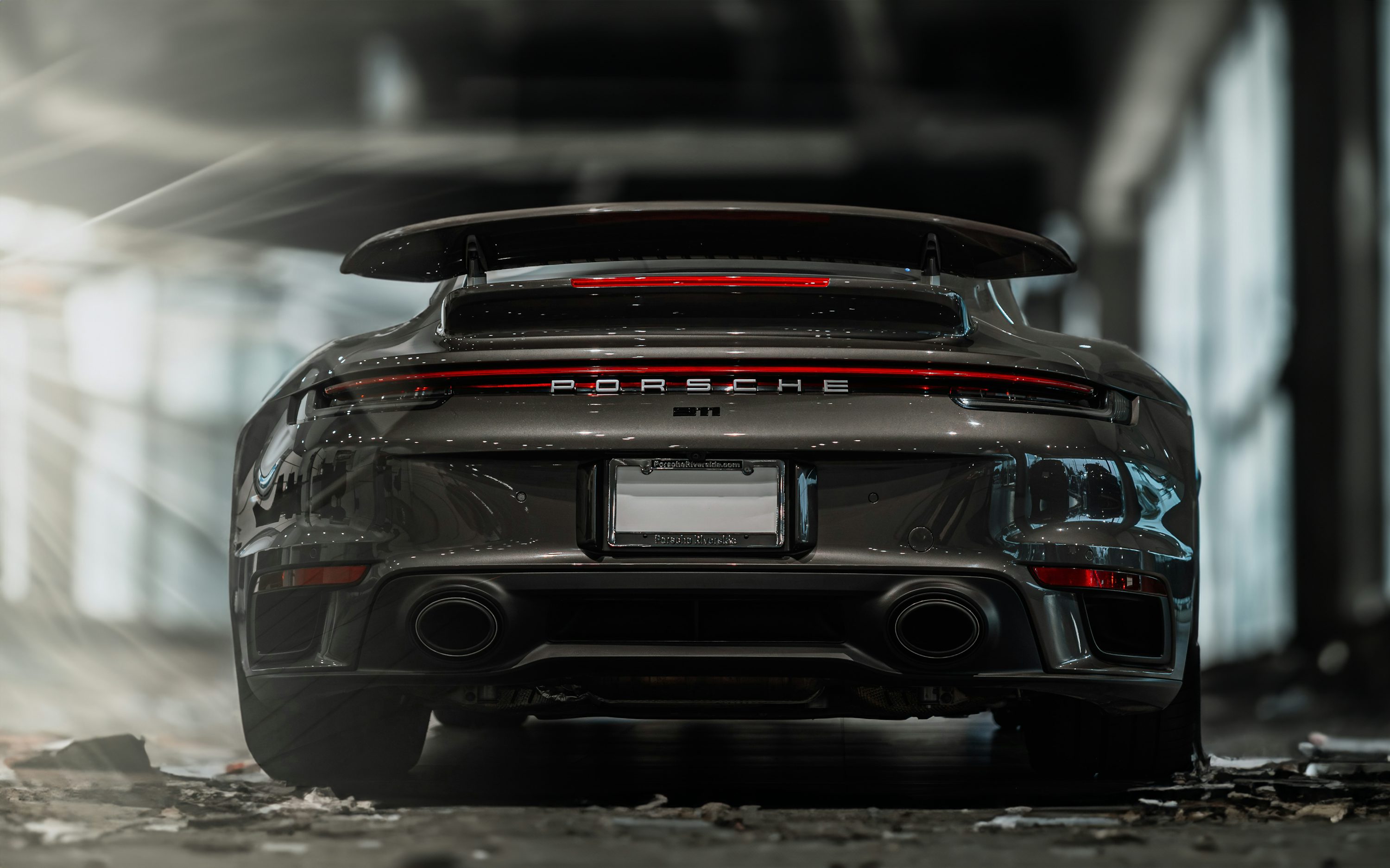 the rear end of a grey porsche sports car