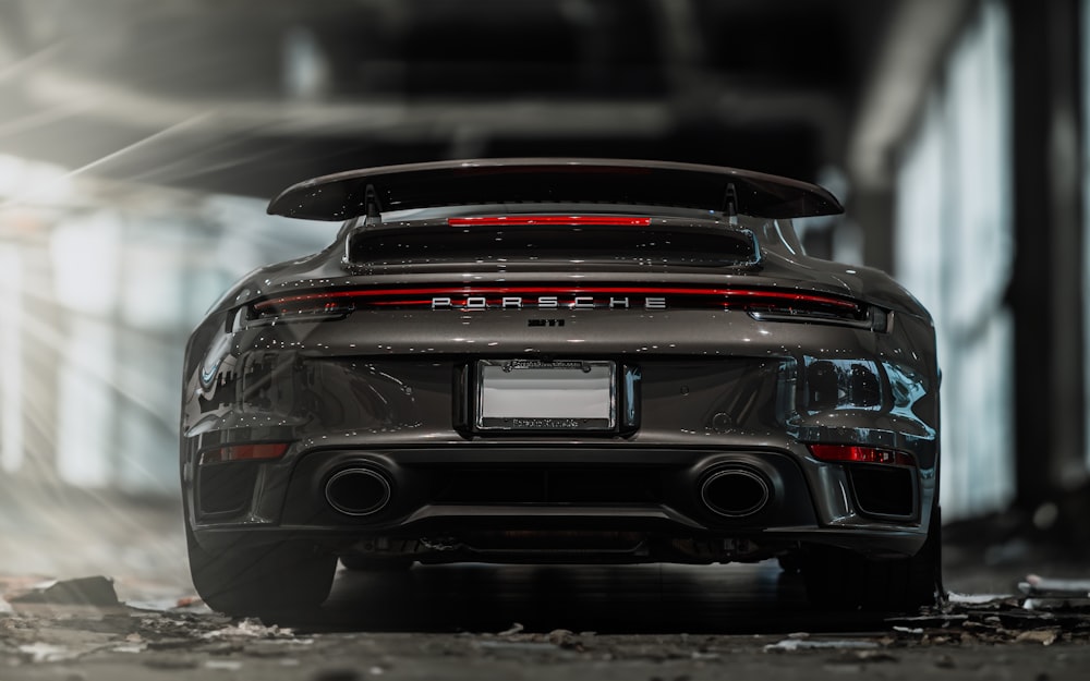 the rear end of a grey porsche sports car