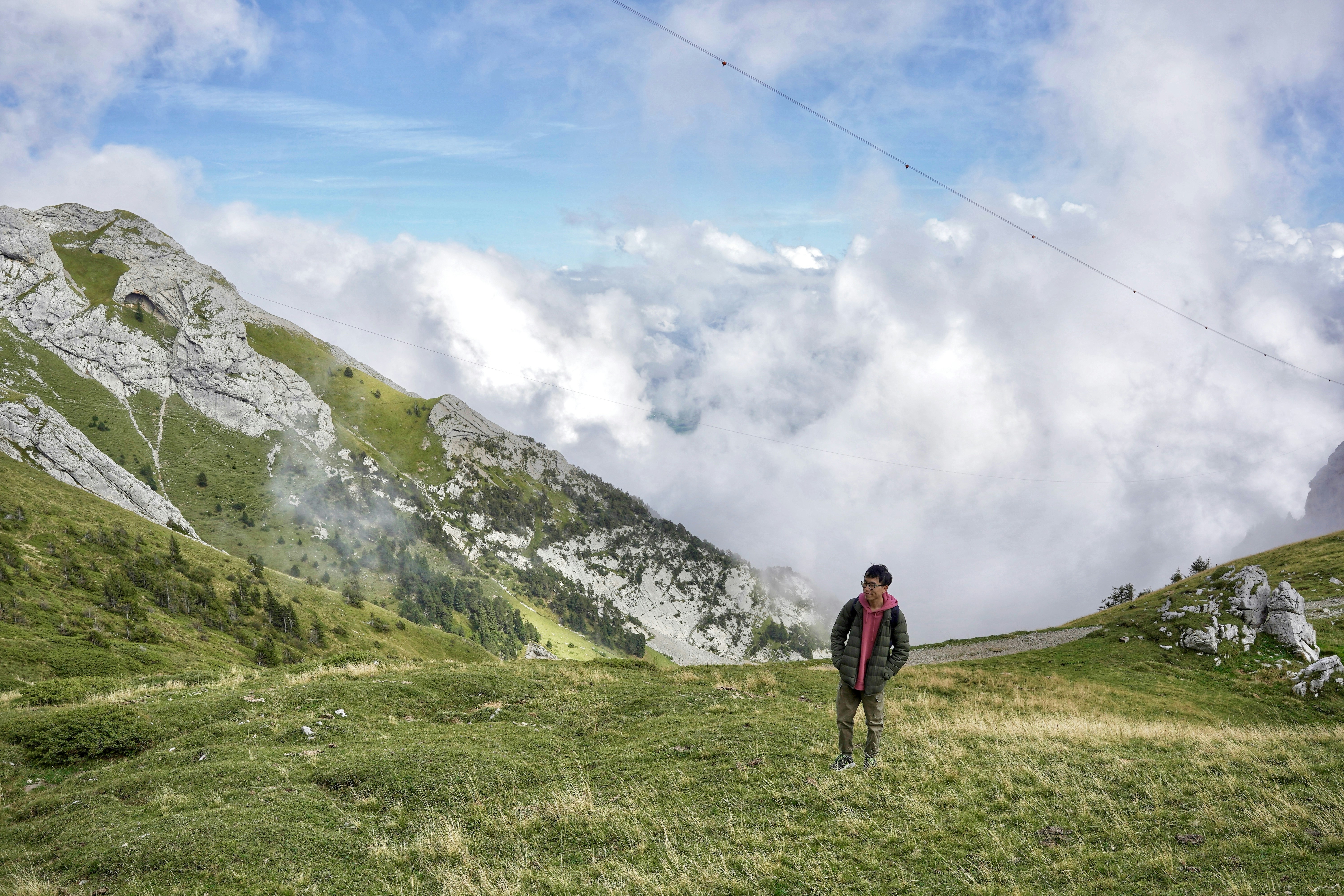 a man standing on top of a lush green hillside