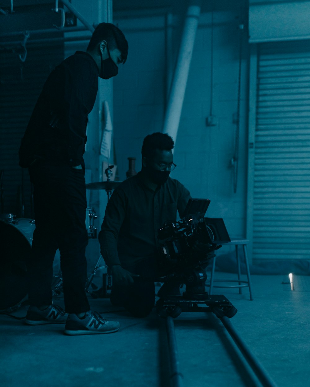 two men in a dark room with a camera