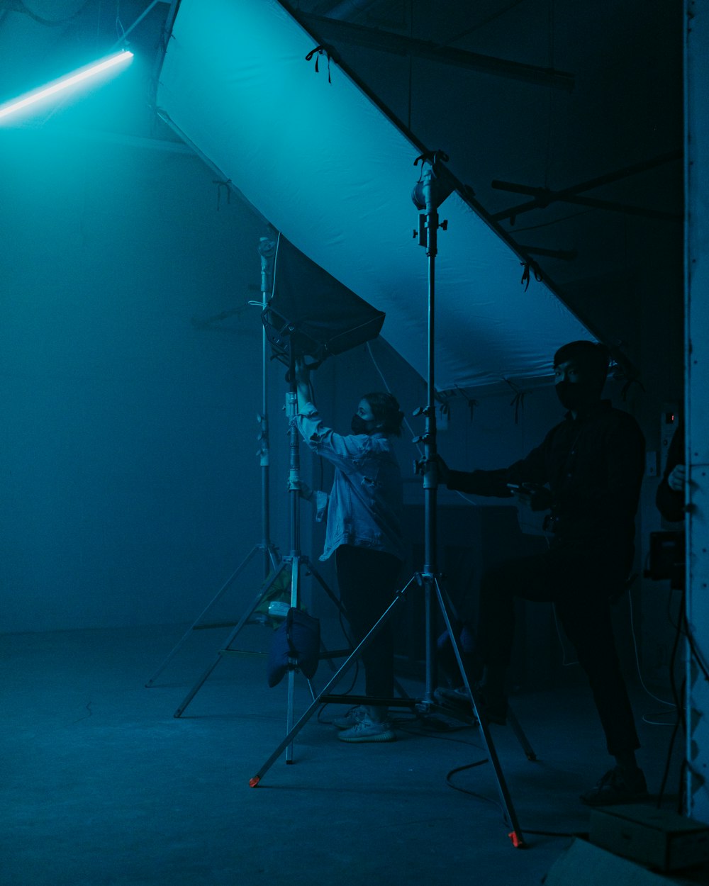a man standing next to a camera in a dark room
