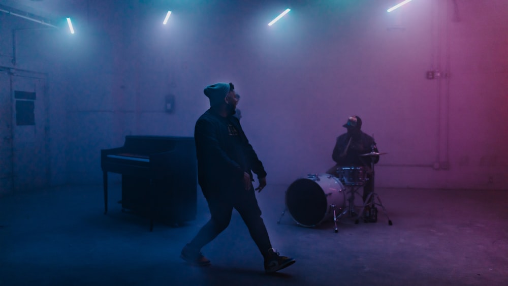 a man standing in front of a drum set