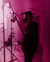 a man standing in front of a pink light