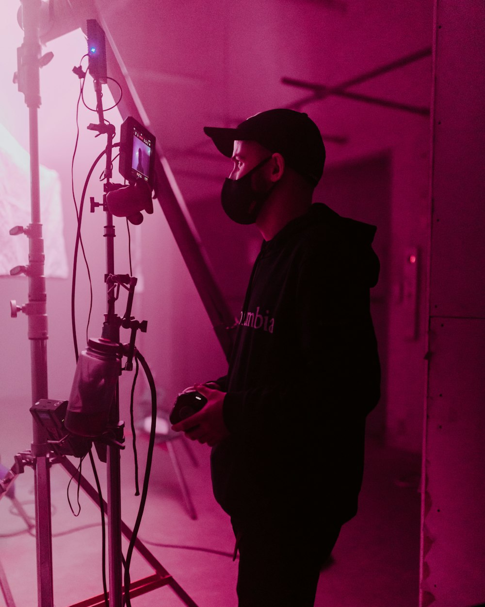 a man standing in front of a pink light