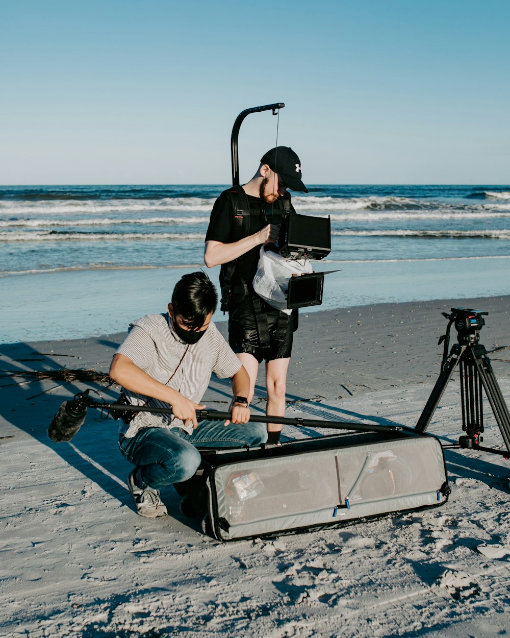 Two people with sound equipment on a beach, creating whoosh sound effects