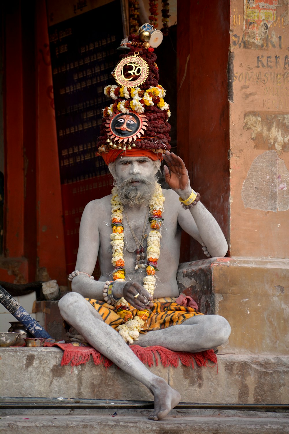 a man sitting on the ground wearing a headdress