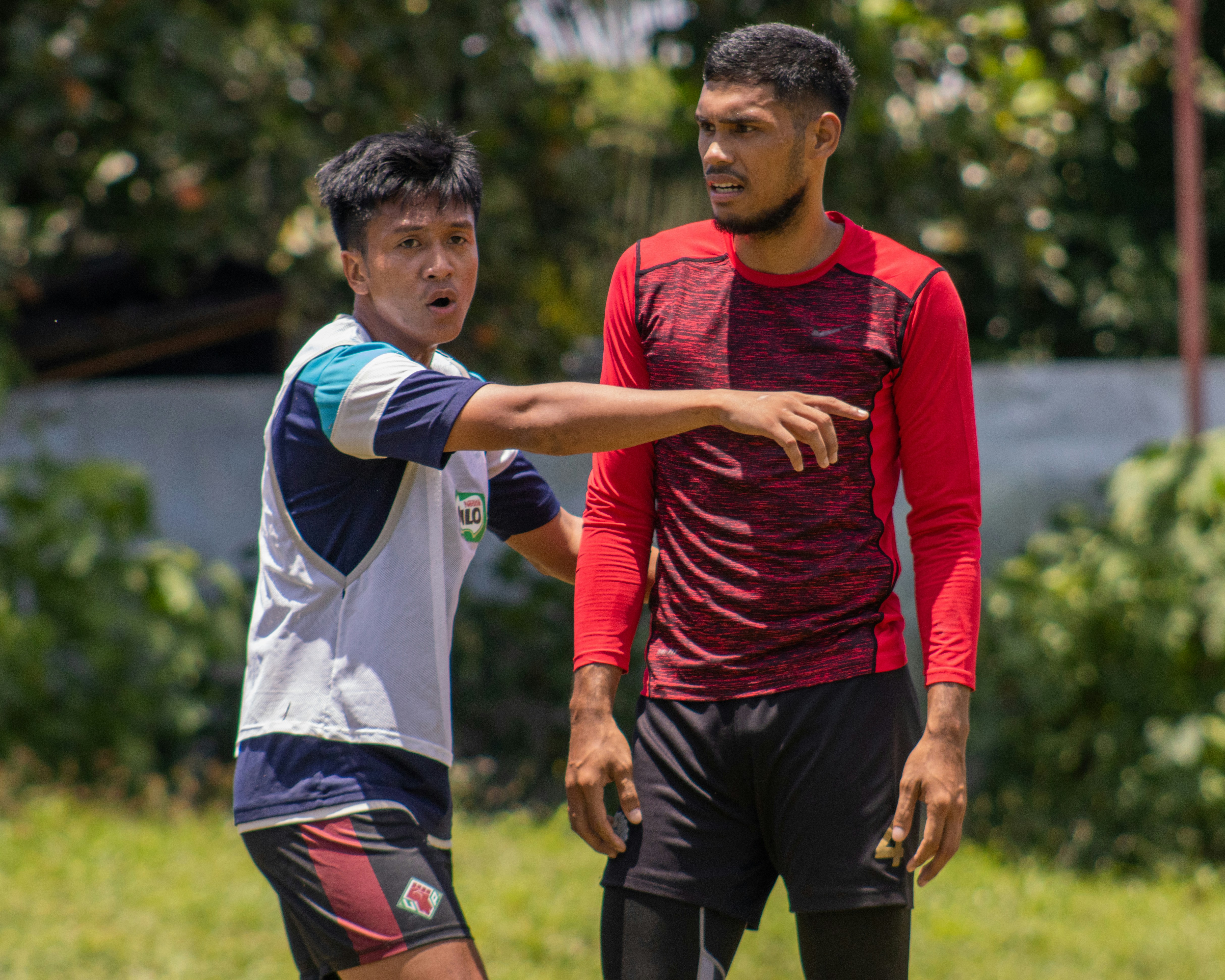 a couple of men standing next to each other on a field